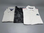 Lote composto por três peças masculinas de manga curta. A primeira é uma camisa polo Lonsdale London, cor branca, tamanho S, com bordado da marca no peito, faixas azul-marinho e vermelha nos ombros e três botões frontais; apresenta sinais de uso. A segunda é uma camisa polo cinza-claro com botão frontal, etiqueta aparente com referência a Tommy Hilfiger. A terceira é uma camiseta gola redonda cinza-escura com estampa floral tonal, marca Reserva, tamanho M. Todas dobradas. Estado de conservação variável, com marcas de uso visíveis especialmente na polo branca. peças masculinas, roupas masculinas, camisas, tops masculinos, indumentária, malhas
