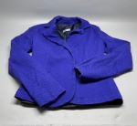 Blazer feminino na cor azul royal, confeccionado em tecido texturizado com padrao em relevo em escamas ou alvéolos. Modelo com gola de lapela, fechamento frontal por botões, mangas longas e forro interno em tecido liso na cor azul marinho. Etiqueta interna com a marca Apis Casual & Basic. Peça apresenta estado de conservação aparente compatível com uso. Tamanho não identificado nas imagens. paletó, casaco, jaqueta estruturada, peça de alfaiataria, roupa feminina, vestuário