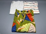 Lote composto por três peças de roupa feminina dobradas. A primeira é uma camiseta de malha branca com listras horizontais nas cores coral e azul-marinho, gola redonda e manga curta, com etiqueta interna visível. A segunda é uma blusa branca de manga longa com textura de bolinhas em relevo (poá). A terceira é uma peça estampada com motivo tropical de folhagens nas cores verde, laranja, azul, amarelo e branco, aparentemente um top ou blusa sem manga. Tamanhos não identificados com precisão. Estado de conservação compatível com uso. Marcas não identificadas. indumentária, peças de roupa, conjunto de blusas, roupas usadas, vestuário casual, lote têxtil