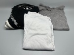 Lote composto por três peças de vestuário: (1) suéter de tricô preto com estampa jacquard em branco, padrões geométricos variados distribuídos pelo corpo e barras, mangas longas com punhos canelados e gola redonda  apresenta etiqueta vermelha na gola, composição não identificada; (2) camiseta manga longa na cor branca, em malha lisa, gola redonda; (3) peça de malha canelada na cor cinza-mescla, gola com acabamento irregular. Tamanhos não identificados. Peças usadas, sem avaliação de estado de conservação individual detalhado. Marcas e composição de tecido não confirmadas. blusa de lã, pullover, moletom, roupa de frio, conjunto de roupas, peças de roupa, blusão