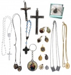 Lote com dezoito objetos religiosos e devocionais. Conjunto composto por crucifixos, terços, medalhas, escapulários, pingentes, correntes, chaveiro, broches religiosos e pequenos objetos de devoção, em diversos materiais, reunidos conforme fotografias. Estado de conservação compatível com o uso e a idade. Medida do maior 40cm.