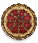 BANDEJA VENEZIANA em madeira, formato circular com borda recortada, ricamente decorada em policromia vermelha, dourada e verde, com motivos florais e ornamentação de inspiração veneziana. Apresenta pátina e sinais de uso compatíveis com a antiguidade. Desgaste do tempo. Diâmetro: 48 cm.