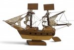 Maquete decorativa de navio veleiro, confeccionada em madeira, com mastros, velas em tecido e cordoamento artesanal. Peça de caráter náutico e decorativo. Mede 23 x 15 cm.