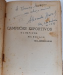 ASSOCIAÇÃO MÁXIMA: Livro Campeões Esportivos 1953 - Com Dedicatória do Autor para Thomaz MazzoniRaridade absoluta e peça de museu para colecionadores de alto padrão de memorabília esportiva nacional. Exemplar original de época do livro "Campeões Esportivos: Olímpicos, Mundiais, Sul-Americanos", publicado em 1953 pela Editorial Andes. Autor: Alexandre Juras. Ano de Publicação: 1953 (Rio de Janeiro). DEDICATÓRIA HISTÓRICA: Folha de rosto enriquecida com dedicatória manuscrita e autografada pelo autor Alexandre Juras, oferecendo a obra com um "abraço amical" ao lendário jornalista, cronista e editor Thomaz Mazzoni. Datado histórica e precisamente do "Rio, 1 de outubro de 1953". Conteúdo: Um registro estatístico e ilustrado pioneiro das conquistas esportivas internacionais do Brasil e do mundo, cobrindo modalidades que vão desde o Atletismo tradicional até o Pentatlo Moderno, detalhando resultados olímpicos históricos de 1920 a 1952 (como as marcas de McCormick e Draves).