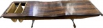 JORGE ZALSZUPIN- Maravilhoso banco/revisteiro dito "ONDA" em jacarandá com estrutura em aço cromado e revisteiro em couro natural.(apresenta selo da LÁtelier). Med. 40 X 170 X 54 cm. Biografia: ZALSZUPIN, Jorge - Varsóvia, Polônia (1922) - Jorge Zalszupin nasceu em Varsóvia, Polônia, em 1922. Formou-se arquiteto na Romênia em 1945. Sua importância para o design brasileiro merece pesquisa, ainda não realizada. Além de ter sido dono da fábrica de móveis l'Atelier, de móveis modernos, Zalszupin liderou uma iniciativa ímpar: coordenou uma equipe de designers que trabalhavam para quatro distintas fábricas de um mesmo grupo empresarial, o grupo Forsa. Esta é uma experiência rara e talvez única no mundo.Zalszupin imigrou para o Brasil em 1949 e, depois de uma breve estadia na capital da República, estabeleceu-se em São Paulo, cidade que entrava num ciclo de grande crescimento industrial e de grandes transformações culturais. Abriu escritório de arquitetura , tendo como sócio José Gugliota, na primeira metade dos anos 1950. Ao cansar-se de projetar e mandar fabricar móveis exclusivos para as residências de seus clientes, decidiu associar-se a um grupo de marceneiros e produzir pequenas séries. Assim surgiu a fábrica l'Atelier, que logo começou a fabricar móveis de escritórios e que passou de uma marcenaria de procedimentos artesanais a uma indústria com produção seriada. A primeira peça desta série foi feita em 1959 e é uma poltrona apelidada de 'Dinamarquesa' pelos funcionários. Construída de jacarandá e estofada, e ela tem pés palito e o desenho de seus braços e pés frontais lembram as colunas projetadas por Niemeyer para o Palácio do Alvorada.No começo dos anos 1970, com sérios problemas financeiros, l'Atelier foi vendida para um grupo empresarial, que já era proprietário da Laminação Brasil (ferragens), da indústria de produtos plásticos Hevea e da fábrica de computadores Labo. A venda foi negociada com o 'passe' de Zalszupin como diretor de pesquisa e desenvolvimento de produtos. Desse modo, Zalszupin ampliou a equipe de designers - que já contava com Oswaldo Mellone - incorporando Paulo Jorge Pedreira e Lílian Weimberg, de forma permanente. Os designers batizaram o grupo empresarial de Forsa e passaram a atuar como laboratório de criação.As possibilidades técnicas oferecidas por quatro distintas plantas industriais foram potencializadas pela equipe de designers. Desta forma, a Hevea, que produzia commodities plásticas, ganhou uma linha de produtos muito sofisticada no desenho e firmou uma marca, a Eva, de utensílios domésticos, vendida em supermercados. A própria l'Atelier passou a usar o plástico injetado, produzindo painéis divisórios para escritórios e licenciando a cadeira de concha de polipropileno Hille desenhada por Robin Day. Além dos produtos que foram ao mercado, a equipe de design do grupo Forsa testou dezenas de novas idéias, que formam extraordinário acervo a ser pesquisado e que, certamente, muito influíram na base de atuação de Oswaldo Mellone e de Paulo Jorge Pedreira.A crise dos anos 1980 afetou profundamente o desempenho das empresas do grupo Forsa. A equipe de design se dissolveu no final da década. Oswaldo Mellone e Paulo Jorge Pedreira abriram seus escritórios individuais e Jorge Zalszupin dedicou-se exclusivamente a arquitetura, atividade que nunca abandonara.A partir de 2005, a empresa Etel Marcenaria passou a produzir vários dos itens projetados por Zalszupin para l'Atelier - entre eles a poltrona 'Dinamarquesa' - , privilegiando os objetos da fase artesanal da empresa.
