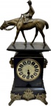 Antigo e Maravilhoso Relógio de Mesa com Caixa em mármore negro ricamente decorado com detalhes florais, cabeças de Cabra e encimado com figura de Jóquei em bronze, ausência do pêndulo, necessita restauro na máquina, no estado. Med. 48 X 23 X 13 cm.