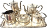 Elegante e Antiga Baixela de Chá/Café em Metal Espessurado a Prata, contendo uma bandeja, um bule de café, um bule de chá, uma leiteira, um açucareiro e uma manteigueira com interior em cristal, peças marcadas embaixo Meridional. Med. bandeja 33 X 53 cm, Med. Bule café 20 X 22 cm, Med. do bule chá 15 X 24 cm.