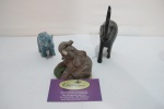 Lote contendo 3 esculturas em elefantes de diversas procedências e materiais. 1 de porcelana vitrificada, 1 de resina e 1 de madeira