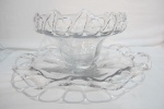 Antiga fruteira com presentoir em vidro translúcido, com bordas vazadas possuí discreta falha borda da fruteira medidas: 37,0 cms diam x 17,5 alt