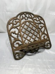 Suporte para Bíblia, livro, confeccionado em ferro fundido, com estrutura ricamente decorado com arabescos vazados. Medindo 39cm x 18,5cm x 30cm de altura.
