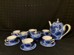 Jogo de servir café com 8 peças em porcelana Argentina, pintado com flores. Sendo um bule com restauro na tampa, acucareiro, leiteira, 5 xicaras e 6 pires. Medindo o bule 17cm de altura. Fotos com o restauro da tampa