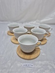 Jogo de 6 xicaras de café em porcelana, relevos. Pires em madeira. Medindo 7cm x 5,5cm de altura.