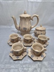 COSTO  - Antigo jogo de servir café com 7 peças em faiança, craquelada, floral. Sendo bule, açucareiro e 5 xícaras. Medindo o bule 19,5cm de altura.