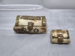 Conjunto de 2 caixas retangulares em osso com acabamento em latão. Medindo a maior 12cm x 7,5cm x 5cm de altura.