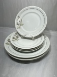 Real - Jogo de 7 pratos em porcelana floral com friso preto. Sendo 3 rasos e 4 de sobremesa. Medindo mesa 26cm de diâmetro, sobremesa 19cm de diâmetro.