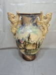 ASSINADO - Lindo vaso monumental em faiança, pintado. Corpo bojudo pintado à mão com cena paisagística europeia e alças laterais escultóricas em formato de leões rampantes.. Medindo 20cm de boca x 40cm alça a alça x 50cm de altura. Contém marcas de restauração.