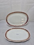 RENNER - Jogo de 2 travessas ovais rasas em porcelana, vinho com ouro. Medindo a maior 33cm x 22cm . Friso com desgaste.