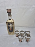 Garrafa licoreira com 5 copos em vidro, moldado. Com propaganda de bebida russa. Medindo a garrafa 27cm de altura, copos 5cm x 5,5cm de altura.