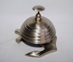Campainha de metal tipo sineta com acionamento por botão superior com a base em formato de âncora . Peça sem uso e na caixa original.