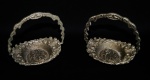 Lote com 2 (duas) cestas de metal prateado fundido com imagens romãnticas do tempo medieval acompanhadas em relevos e guirlandas. Medidas 12x12cm.