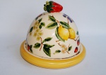 Queijeira em porcelana do renomado LUIZ SALVADOR ricamente policromada com motivos de florais e frutas e ostentando morango no puxador da tampa. Medida 20 cm de diâmetro e 18 cm de altura