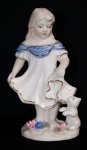 Estatueta de porcelana de menina com cão com riqueza de detalhes e aplicação de filetes de ouro. Medida 15cm de altura