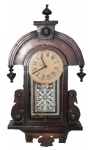 Antigo relógio de parede capelinha em caixa de madeira trabalhada. Medida 19X39 cm. Lote com funcionamento desconhecido.