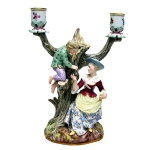 Candelabro / grupo escultórico em porcelana alemã de Meissen representando Maternidade. Braços fitomorfos e bobeches com pintura floral, século XIX. Meds: 23,5 cm 18,5 cm