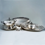 Baixela em metal Wolff espessurado à prata constando de 5 travessas ovais, 2 pratos redondos, uma sopeira, uma legumeira e uma molheira. Meds: 21,0 cm x 33,0 cm (sopeira)