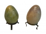 Lote contendo 2 ovos de pedras brasileiras com suportes de metal, medindo 8 cm alt.