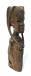 ARTE AFRICANA - Escultura representando mulher de joelhos carregando criança em suas cestas. Med. 43 cm.