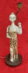 Grupo escultórico em cerâmica, representando figura feminina, adaptado para abtjur, altura 62cm e base com 20cm de diâmetro.