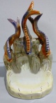 Grupo escultório e porcelana representando trono marinho. Mede: 40 x 23 x 24 cm. Reparos na cauda dos peixes