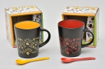 Lote constando duas canecas para café confeccionadas em porcelana decoradas com silks coloridos em motivação de "café". Acompanham colheres.
