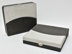 Par de caixas porta documentos confeccionadas em couro sintético nas cores preta e cinza, fecho em metal. Med.: 8x32x35 cm.