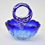 Lindo centro de mesa decorativo confeccionado em grosso vidro de Murano na cor azul, em forma de cesta, com bojo bomado, alças circulares terminadas em flores e borda ondulada. Med.: 24x22 cm.