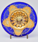 Excepcional centro de mesa circular em vidro veneziano na cor azul apresentando riquíssima decoração pintada a mão em esmaltes florais e folha de ouro, base gomada. Med.: 8x41 cm.