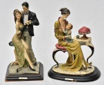 Lote constando duas estatuetas decorativas confeccionadas em resina italiana ricamente policromada, uma delas representando "casal em dança" e outra representando "madona". Bases no estado. Med.: 28x11 cm e 26x16 cm.