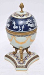 - Excepcional Ovo europeu estilo Luiz XVI, em porcelana decorada c/ cena clássica em monocrômia azul c/ detalhes em ouro brunido, guarnições em bronze dourado e cinzelado, bojo na forma de ovo ao gosto Faberge, selo do importador, alt. 32cm.