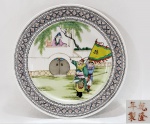 Prato em porcelana chinesa, período Republicano (1912 / 1949), pintado a mão com cena de jardim, donzela e guerreiros. Assinado com marca apócrifa QIAN LONG de 4 caracteres. Med. 26 cm.