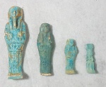 ARQUEOLOGIA - Lote com 3 ushabtis e 1 amuleto egípcio em faiança vitrificada azul turquesa com estilos diversos, sendo o maior com caraterísticas do período Ptolomaico e a menor, um amuleto da deusa Ísis com Hórus sendo amamentado. Medida do maior 10 cm e do menor 4,5 cm.