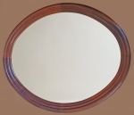 Grande espelho oval com moldura em jacarandá; anos 60. Med. 97 x 83 cm.
