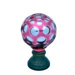 Pinha em cristal Baccarat em formato globular com overlay na cor rubi, lapidada em reservas de esferas, interior espelhado, século XIX. Altura: 13,5 cm.