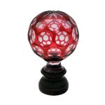 Pinha em cristal Baccarat com overlay vermelho, lapidada com reservas de esferas e estrela no topo, século XIX. Altura: 17,5 cm.