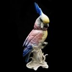 Cacatua em porcelana alemã Kals Ens Volksted com fina e bela anatomia e plumagem, pousada sobre tronco, marcada no fundo. Altura: 21,0 cm