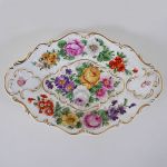 Fruteira em porcelana alemã `EDELSTEIN BAVARIA`, com rica pintura floral e molduras douradas de volutas em relevo. Meds: 31,0 cm x 20,3 cm x 5,0 cm
