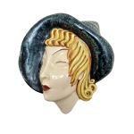 Máscara em faiança italiana no estilo Art Decó com rosto feminino. Med: 31 x 29  cm