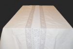 Grande toalha de banquete, em linho creme, com faixas bordadas em flores. Medindo 308x142 cm.Apresentando pequenos pontos de manchas amareladas.