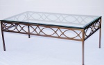 Bela mesa de centro de sala em ferro trabalhado e patinado com espesso tampo em vidro bisotado. Medida 60x110 cm. Apresenta discretíssimo lascado no vidro.