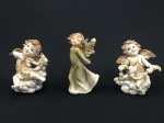 Lote constando três delicadas estatuetas decorativas confeccionadas em material sintético, policromadas, representando "anjos". Med.: 12,5 cm e 14 cm.